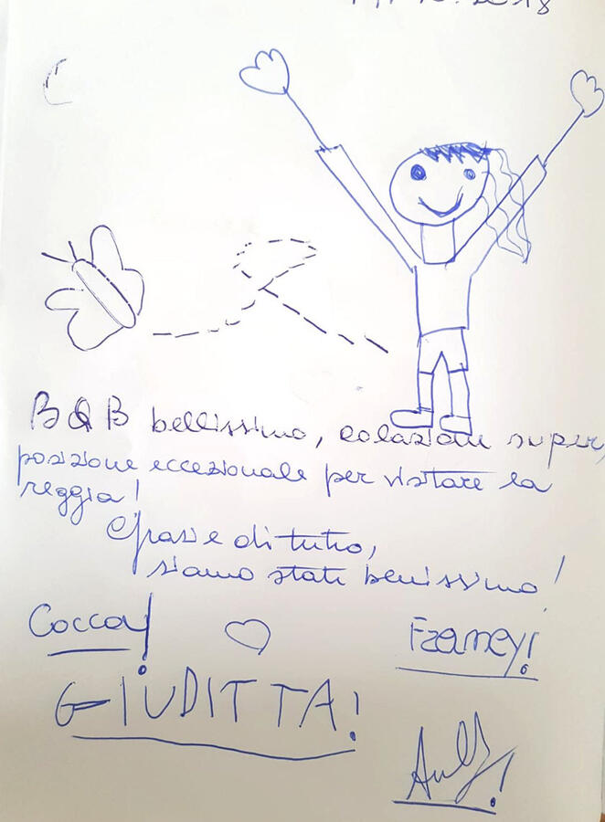 Pagina del quaderno con un disegno e i saluti di una bambina